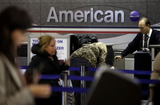 Travelers check in at an American Airlines counter at LaGuardia Airport in New York, Tuesday, Nov. 29, 2011. American Airlines and its parent company are filing for Chapter 11 bankruptcy protection as they seek to cut costs and unload massive debt built up by years of high jet fuel prices and labor struggles.